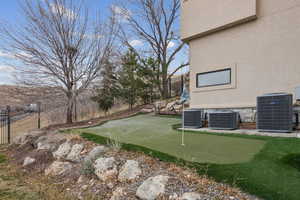 Fenced backyard with a putting area and a patio