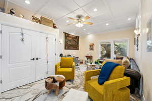 Living room featuring recessed lighting, coffered ceiling, and ceiling fan