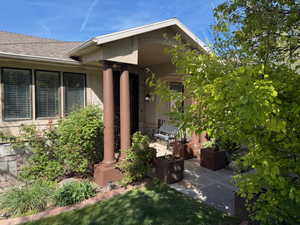 Doorway to property featuring roof with shingles