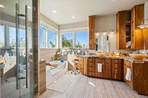 Bathroom with double vanity, a bath, a stall shower, and recessed lighting