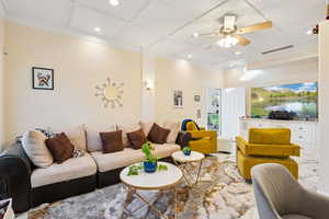 Living area with coffered ceiling, recessed lighting, and a ceiling fan