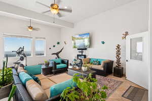 Living area featuring ceiling fan and light tile patterned floors