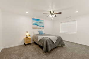 Carpeted bedroom featuring ceiling fan and recessed lighting