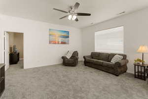 Living area featuring ceiling fan and light colored carpet