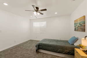 Carpeted bedroom featuring a ceiling fan and recessed lighting