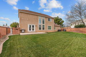 Back of house featuring a gate, a fenced backyard, a patio, and stucco siding