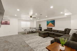 Living area featuring light carpet, a ceiling fan, and recessed lighting