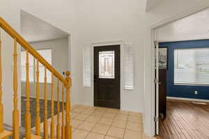 Foyer entrance with light tile patterned floors and a textured ceiling
