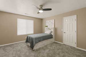 Bedroom with carpet floors, a ceiling fan, and a textured ceiling