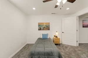 Carpeted bedroom with ceiling fan and recessed lighting