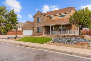 View of front of house with a porch, driveway, brick siding, a tile roof, and an attached garage