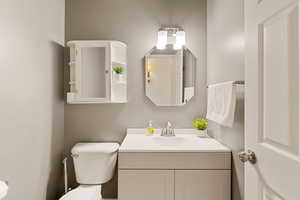 Half bathroom with vanity and a textured wall