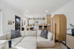 Living area featuring crown molding and recessed lighting