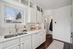 Kitchen featuring white cabinetry, dark wood-type flooring, backsplash, and open shelves