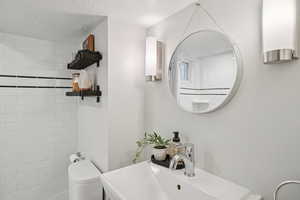 Bathroom with a textured ceiling and vanity