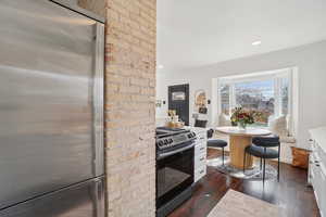 Kitchen featuring stainless steel appliances, ornamental molding, white cabinetry, dark wood finished floors, and recessed lighting