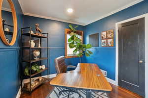 Home office with crown molding and dark wood-style flooring