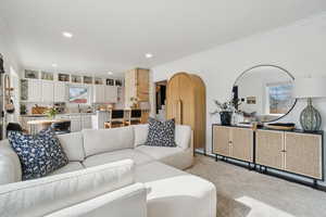 Carpeted living room with ornamental molding and recessed lighting