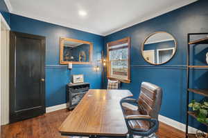 Home office with dark wood-style floors and ornamental molding
