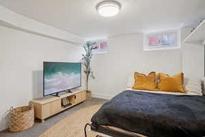 Carpeted bedroom with baseboards and a textured ceiling