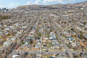 Aerial view of property and surrounding area featuring a mountainous background and nearby suburban area