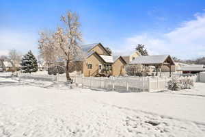 Snow covered rear of property featuring a residential view