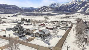 Snowy aerial view with a mountain view and a residential view