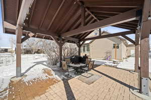 Snow covered patio with a patio, area for grilling, and outdoor dining area