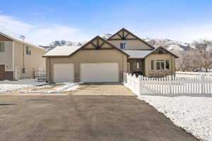 Craftsman inspired home featuring driveway, an attached garage, a mountain view, and stucco siding