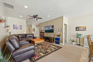 Living room featuring ceiling fan, light carpet, recessed lighting, and light wood finished floors
