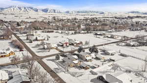 Snowy aerial view featuring a mountain view and a residential view