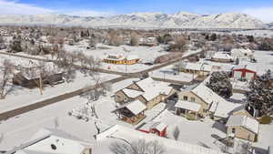 Snowy aerial view with a mountain view and a residential view