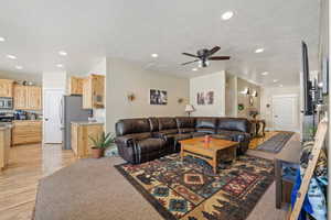 Living room with a ceiling fan, recessed lighting, and light wood-type flooring