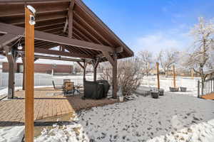 Snow covered patio with a patio and area for grilling