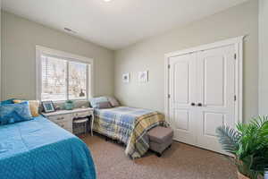 Bedroom featuring dark colored carpet and a closet