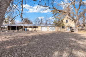 View of front facade with a carport, a metal roof, and stucco siding