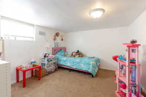 Bedroom featuring light carpet and baseboards
