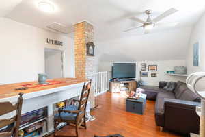 Cottage upstairs living room featuring lofted ceiling, wood-type flooring, and a ceiling fan