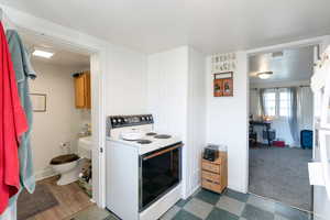 Cottage Kitchen featuring white electric range oven and dark floors
