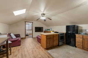 ADU Kitchen with wood finish cabinets, a ADU Greatroom w/ kitchen peninsula, open floor plan, freestanding refrigerator, and stainless steel range with electric stovetop