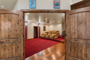 Home theater room featuring dark wood finished floors, recessed lighting, and dark carpet