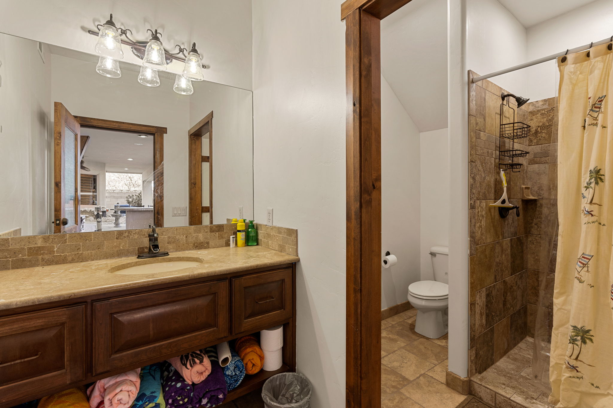 Outside Pool Bathroom featuring a stall shower, vanity, and light stone finish flooring