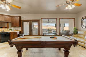 Rec room with a ceiling fan, stone tile floors, pool table, french doors, and a mountain view