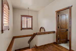 Hall featuring wood-type flooring and an upstairs landing