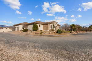 Mediterranean / spanish house with stucco siding, a garage, driveway, and a tile roof