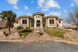 Mediterranean / spanish-style home with a front yard, stucco siding, and a tiled roof