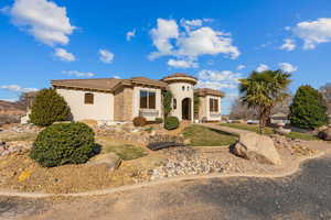 Mediterranean / spanish-style house with a tiled roof, stucco siding, and stone siding