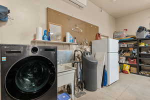 Laundry area featuring washer / clothes dryer, concrete flooring, and a mini split for heating / cooling