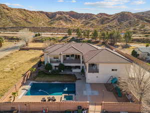 Back of property featuring a fenced backyard, a patio, a mountain view, and a balcony