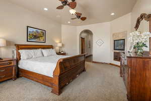 Primary Owner Suite with light carpet, a ceiling fan, arched walkways, and recessed lighting